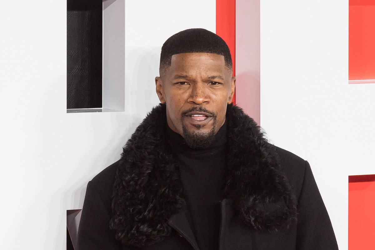 Jamie Foxx in a fur coat posing at the premiere of 'Creed III'.