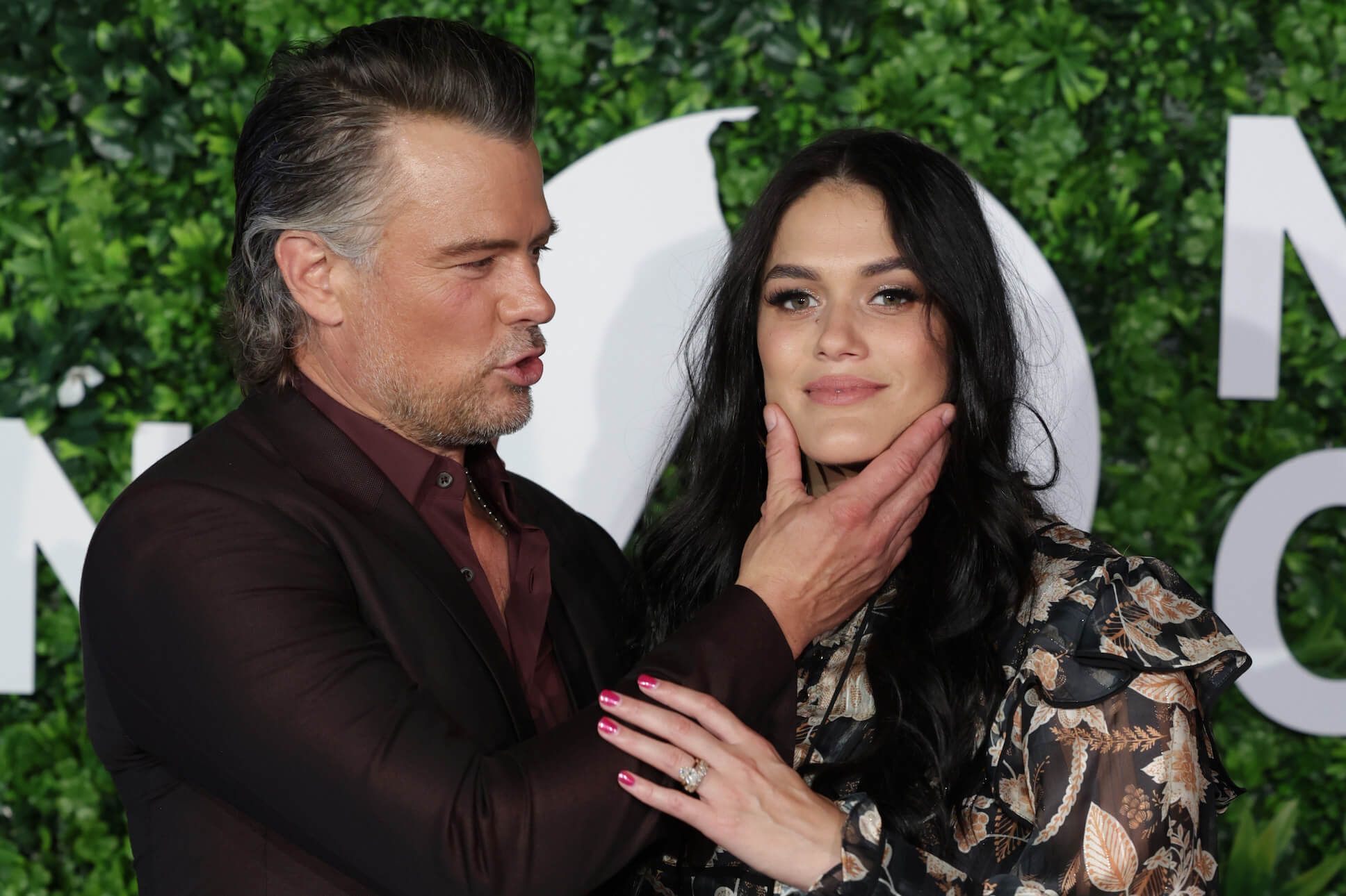 Josh Duhamel holding the face of his wife, Audra Mari, at an event. They have over 20 years age difference