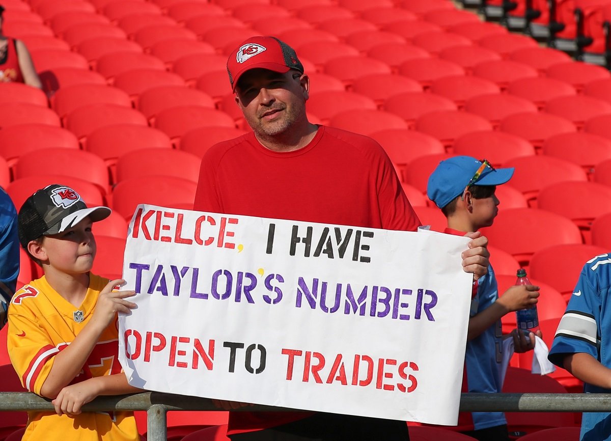 Kansas City Chiefs fans hold a sign joking with Travis Kelce about Taylor Swift's phone number