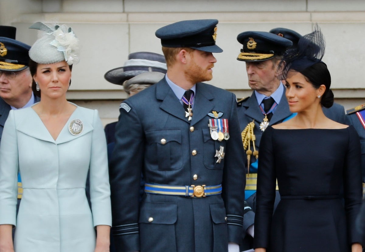 Kate Middleton, Prince Harry, and Meghan Markle, who a biographer says will never curtsy to her sister-in-law, attend a ceremony at Buckingham Palace in 2018