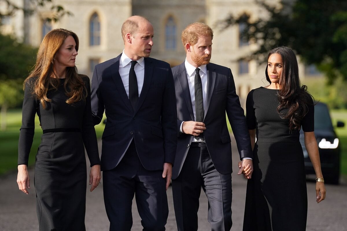 Kate Middleton, Prince William, Prince Harry, and Meghan Markle view tributes left at the gates of Windsor Castle to Queen Elizabeth II