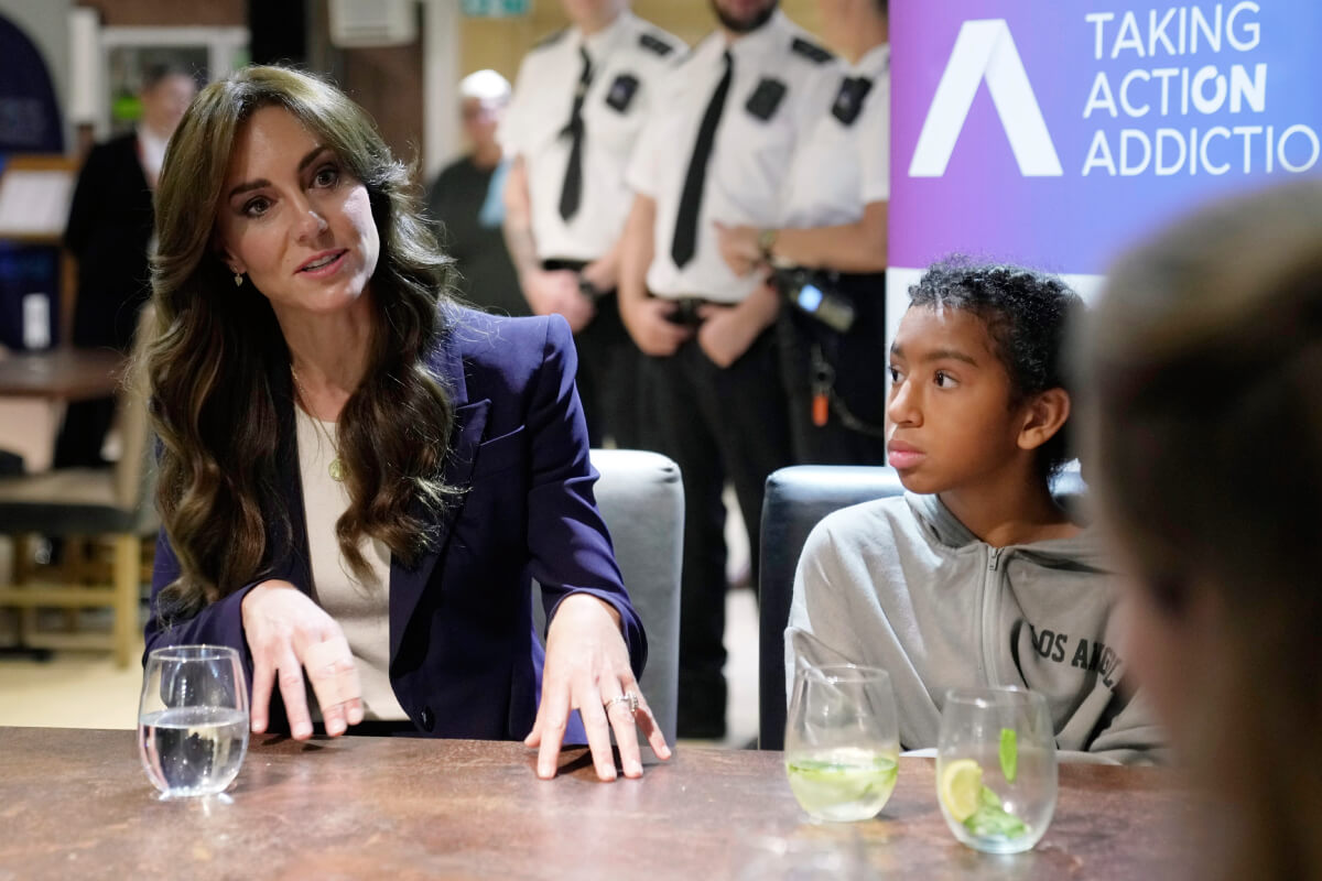 Kate Middleton, sits with a child during a visit to a correctional facility in Surrey