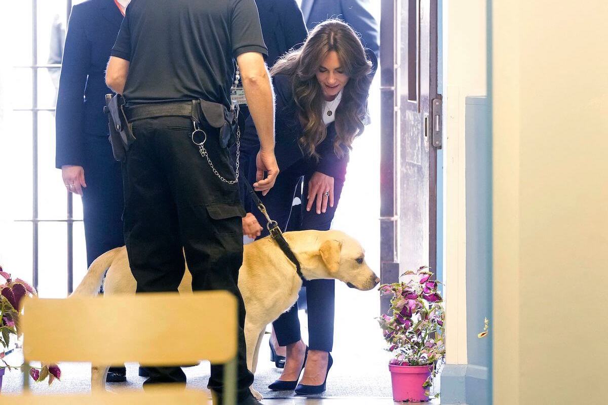 Kate Middleton, who took after Princess Diana on a prison visit, greets a dog