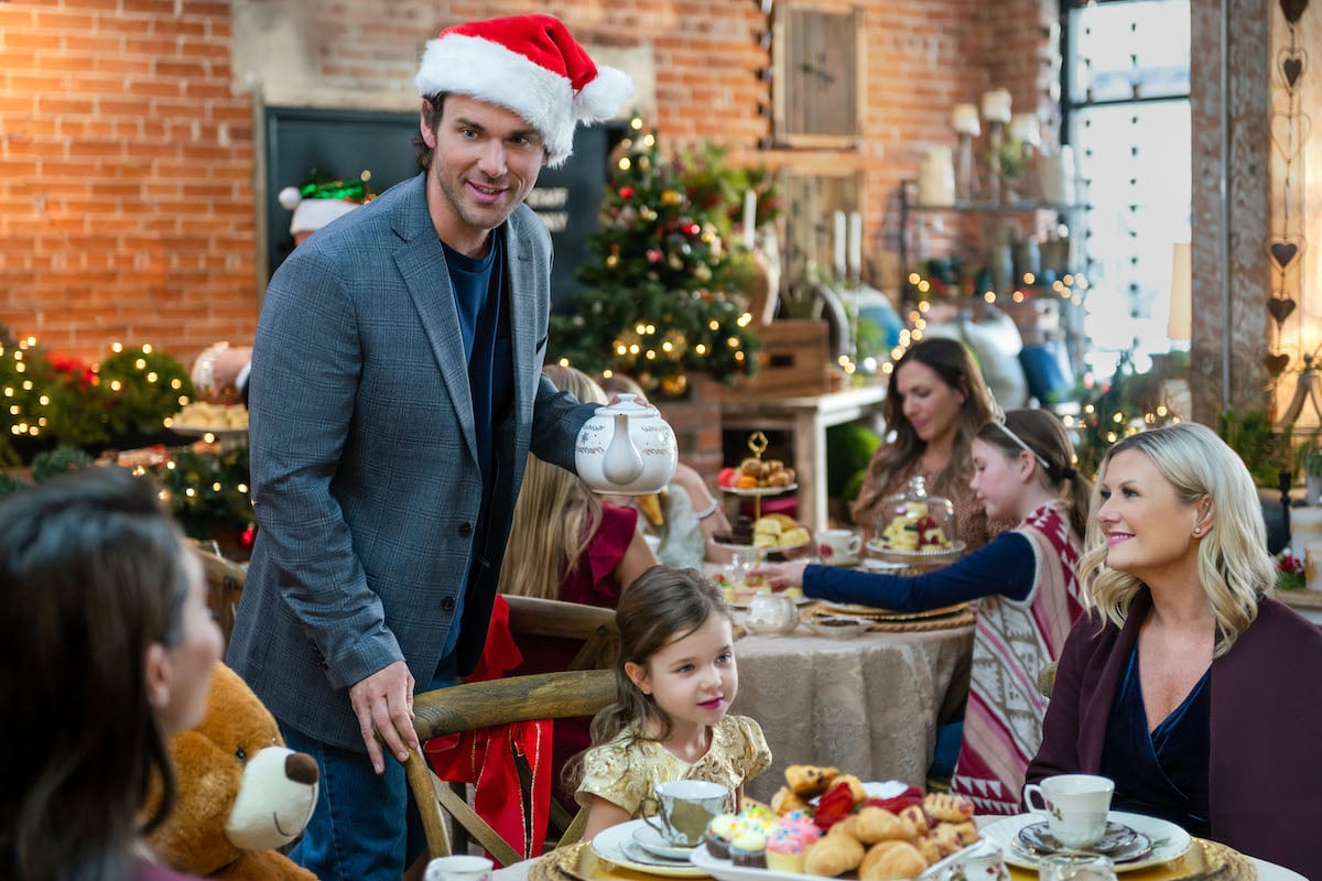 Kevin McGarry wearing a Santa hat and talking to a table of people in 'Checkin' It Twice'