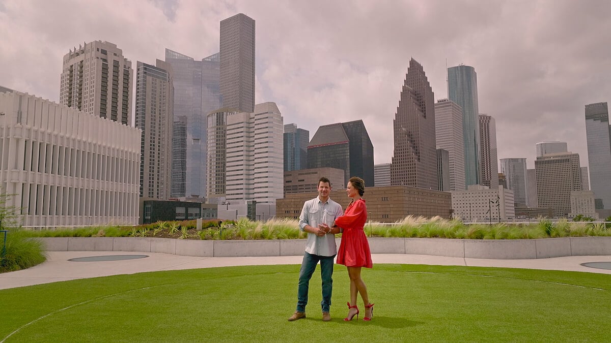 Vanessa and Nick Lachey standing in a park in front of the Houston skyline, where 'Love Is Blind' Season 5 was filmed