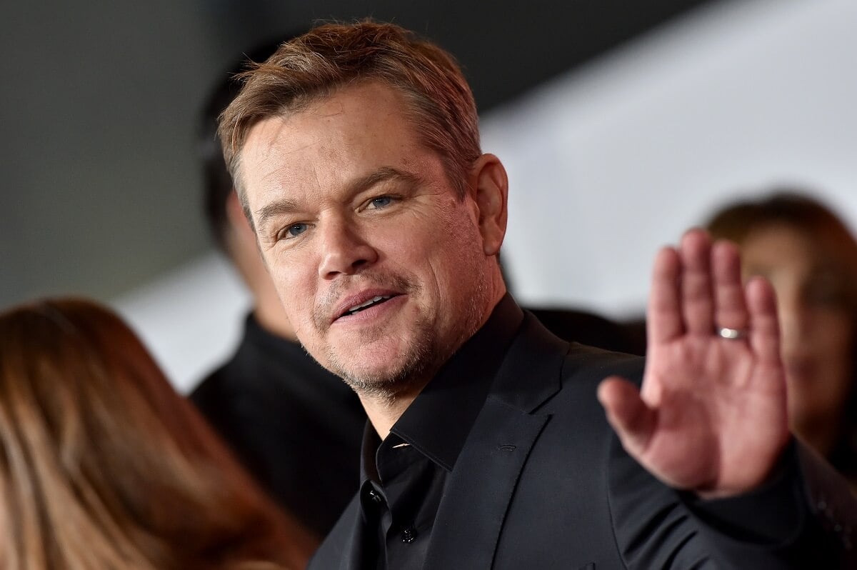 Matt Damon smiling in a suit at the Premiere of FOX's "Ford v Ferrari" .