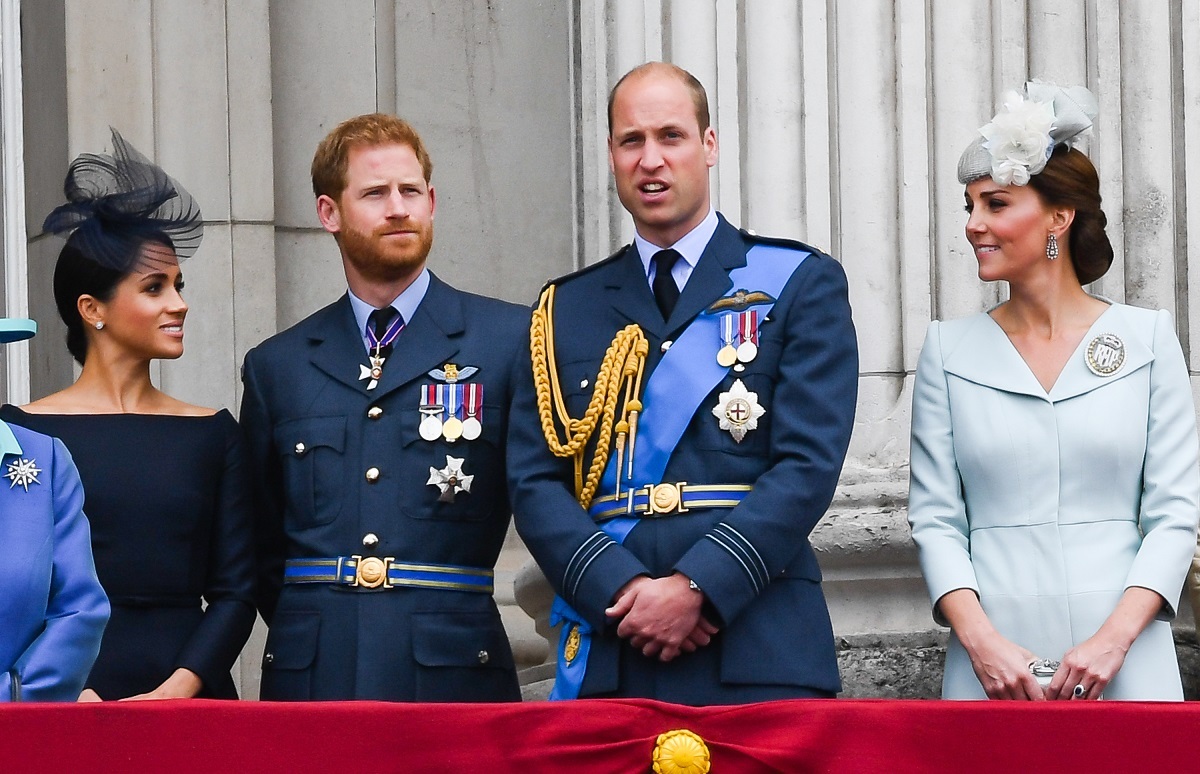 Meghan Markle, Prince Harry, Prince William, and Kate Middleton standing on the balcony of Buckingham Palace to view a flypast
