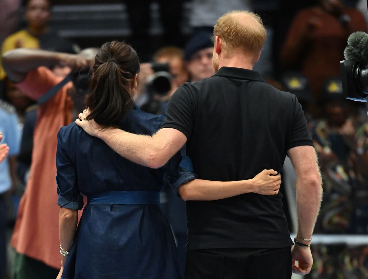 Meghan Markle and Prince Harry walking with their arms around each other as they attend the sitting volleyball final at Invictus Games Düsseldorf 2023