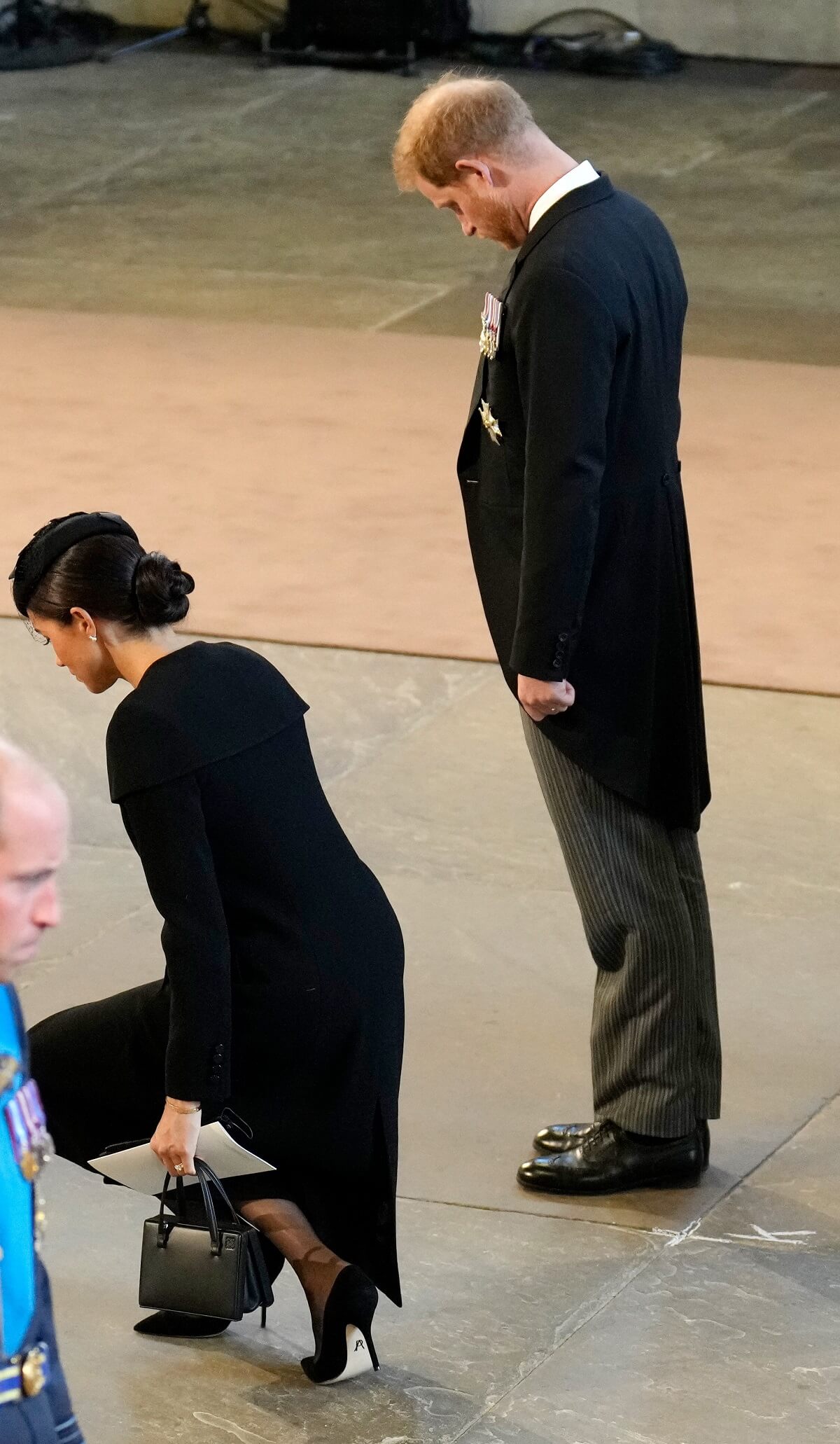 Meghan Markle curtsying and Prince Harry bowing as they pay their respects to Queen Elizabeth II