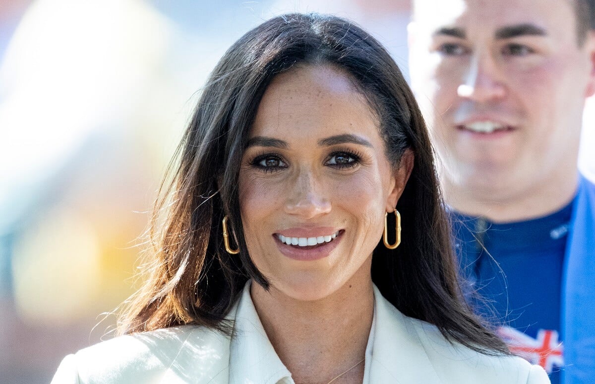Meghan Markle, who a body language expert says wears white or cream as a 'power color,' attends the cycling at the Invictus Games