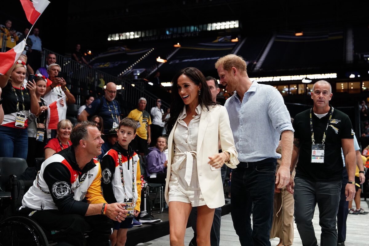 Meghan Markle, whose Invictus Games outfits had a Kate Middleton connection, walks with Prince Harry