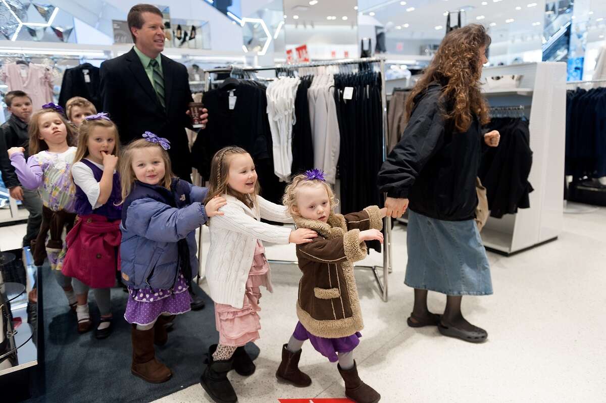 Jim Bob and Michelle Duggar walk through a store with several of their children during a visit to New York City in 2014