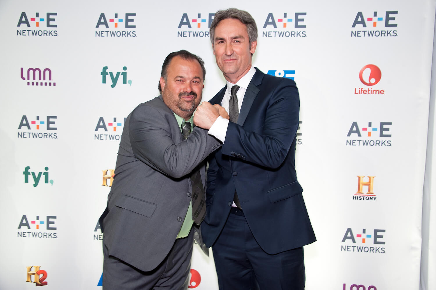 Frank Fritz and Mike Wolfe from 'American Pickers' wearing suits and smiling at an event