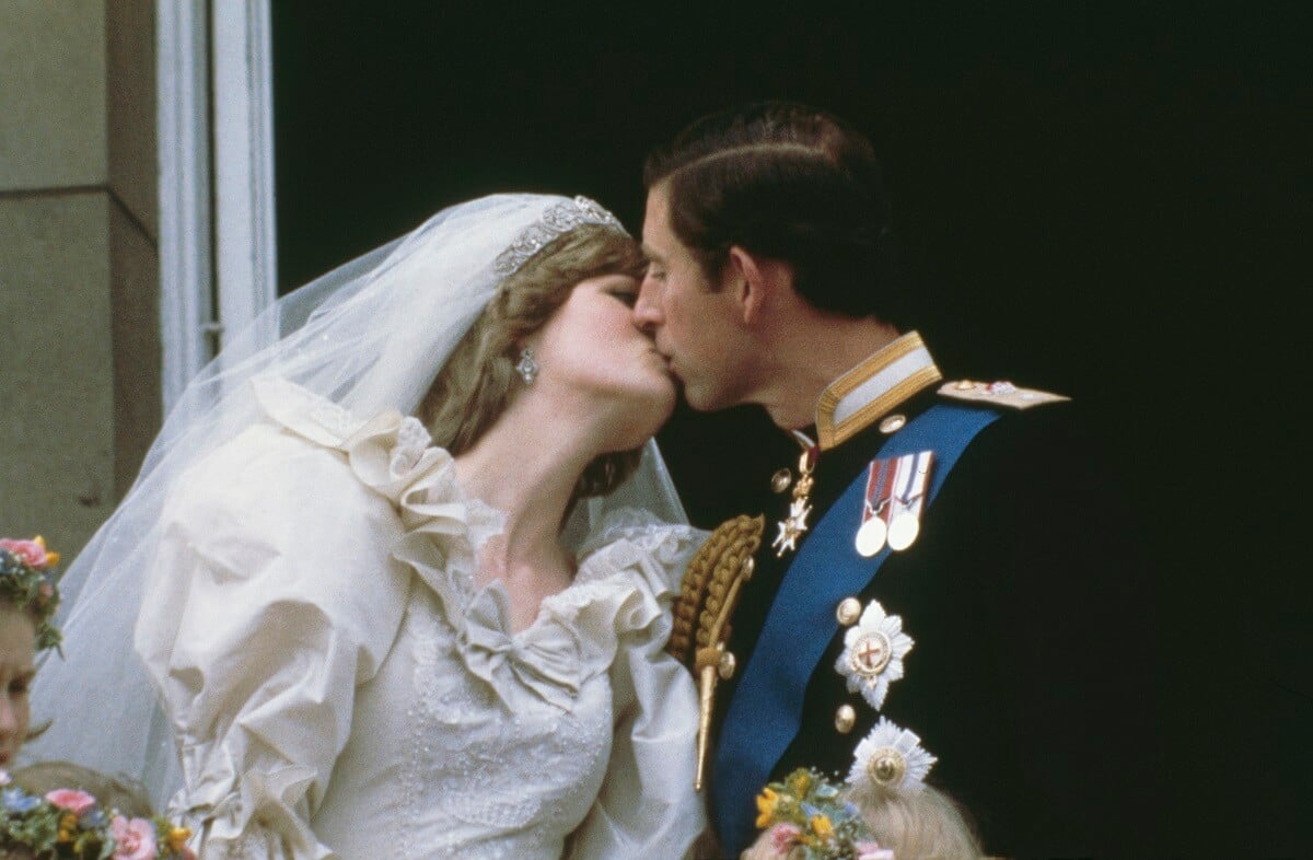 Now-King Charles kissing his first wife, Princess Diana, on the balcony of Buckingham Palace following their wedding