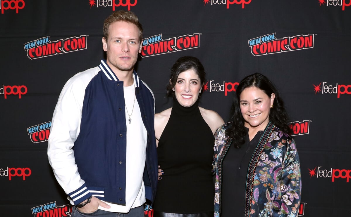 Sam Heughan, Maril Davis, and Diana Gabaldon pose for a photo together at the Outlander panel during Day 3 of New York Comic Con 2021 at Jacob Javits Center on October 09, 2021