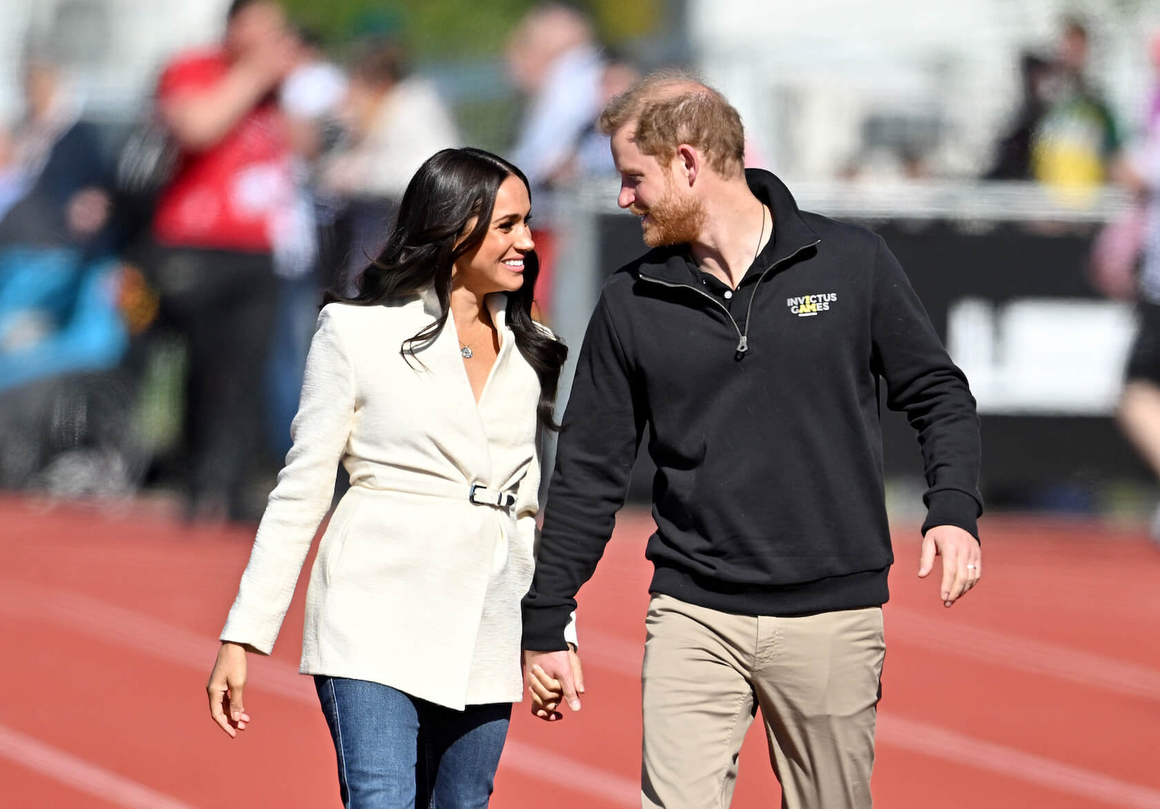 Prince Harry and Meghan Markle smiling and holding hands