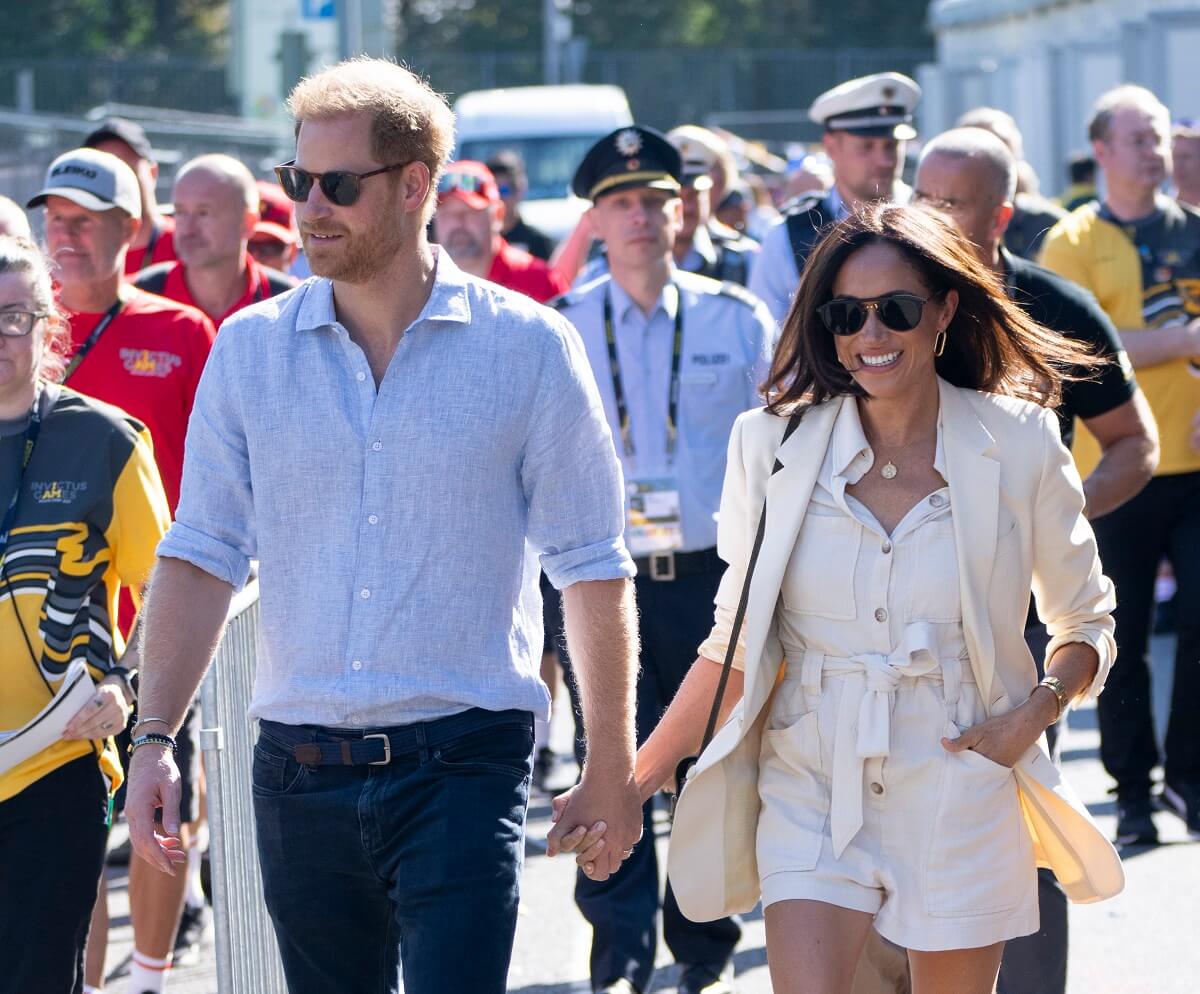 Prince Harry and Meghan Markle holding hands as they walk to attend the cycling during the Invictus Games