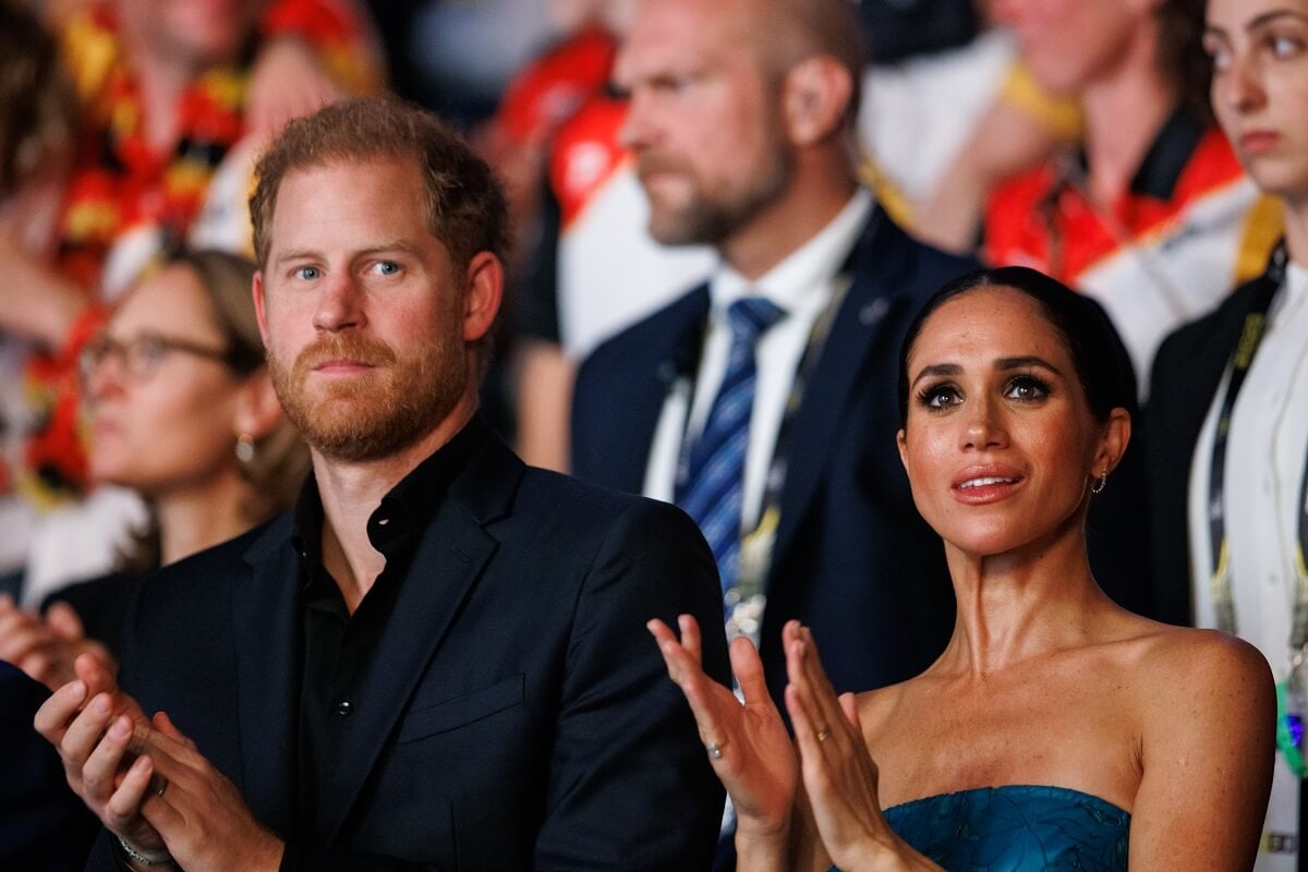 Prince Harry and Meghan Markle, who a body language expert says kept up the PDA to 'look like A-list celebrities,' are seen during the closing ceremony of the 2023 Invictus Games