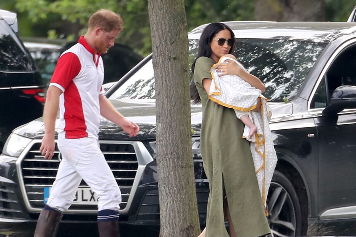 Prince Harry and Meghan Markle, who an author says have 'stored up trouble for their children,' with their son Prince Archie at The King Power Royal Charity Polo Day in 2019