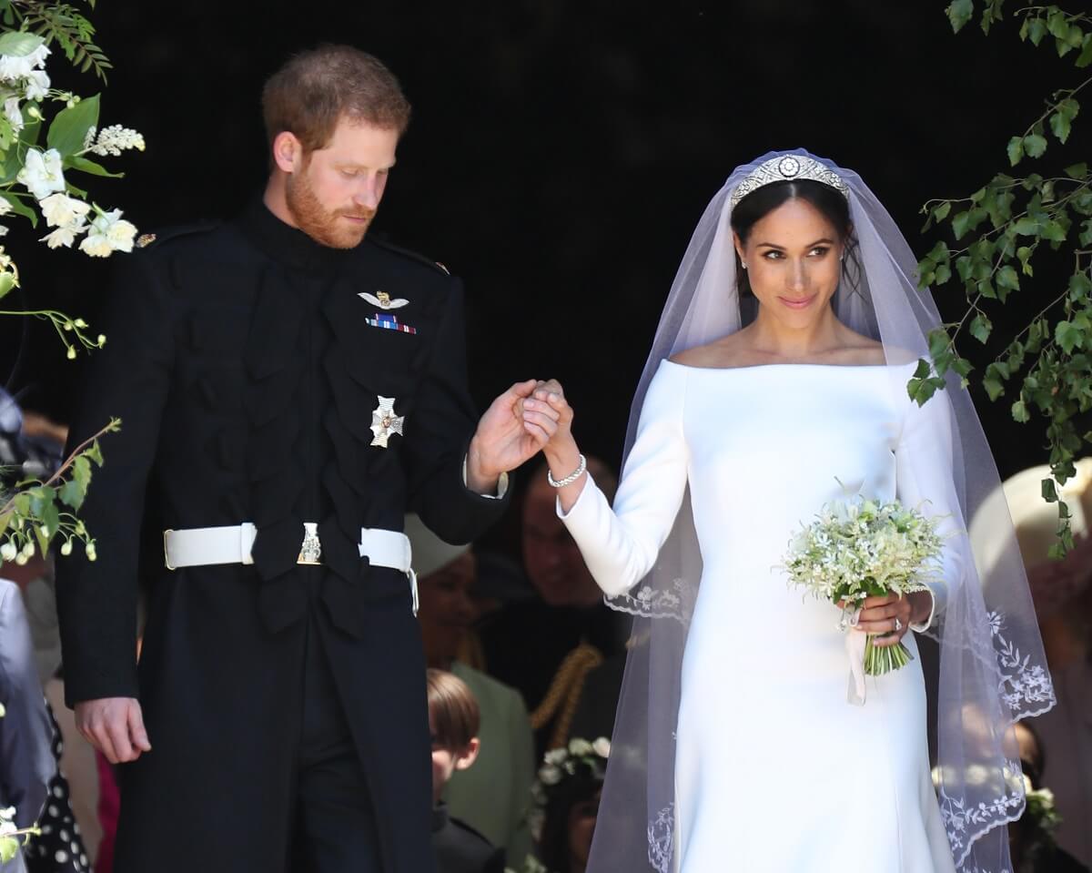 Prince Harry and Meghan Markle, who was preoccpied with her dress in viral video, leave St George's Chapel after their wedding ceremony