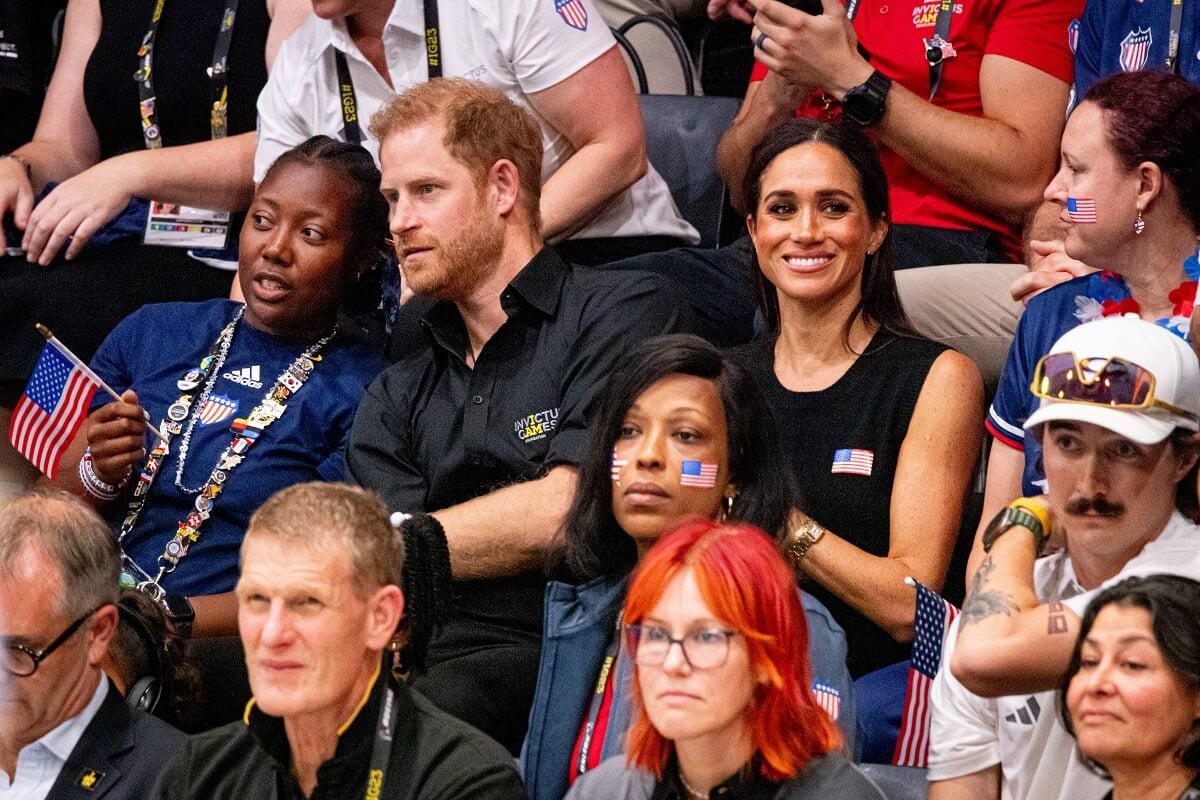 Prince Harry speaking to someone next to him as he and Meghan Markle are seen at the wheelchair basketball final between the United States and France at Invictus Games