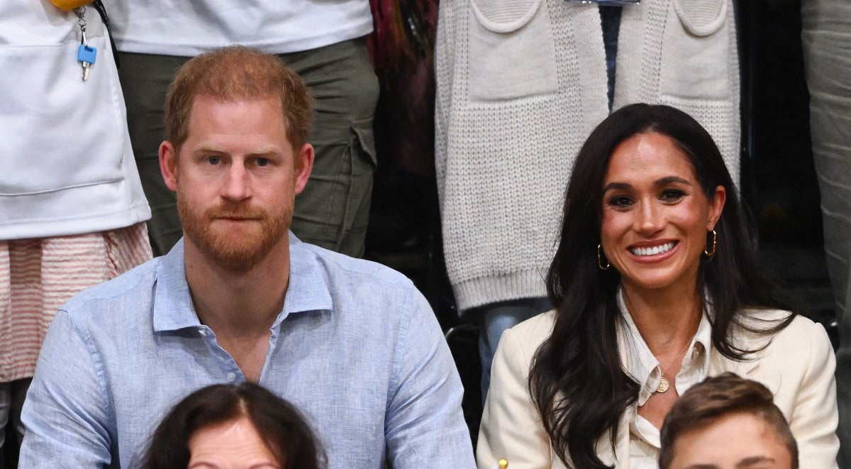 Prince Harry, who a body language expert says was 'nervous' as Invictus Games appearance turned into 'The Meghan Show,' sitting with wife Meghan Markle at a volleyball match
