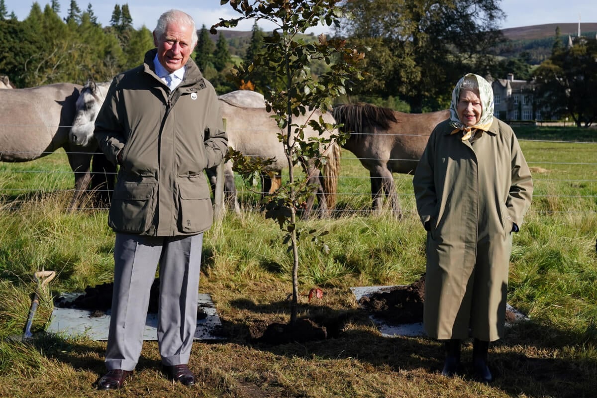 Queen Elizabeth II and Britain's Prince Charles, Prince of Wales pose alongside the tree which they planted to mark the start of the official planting season for the Queen's Green Canopy