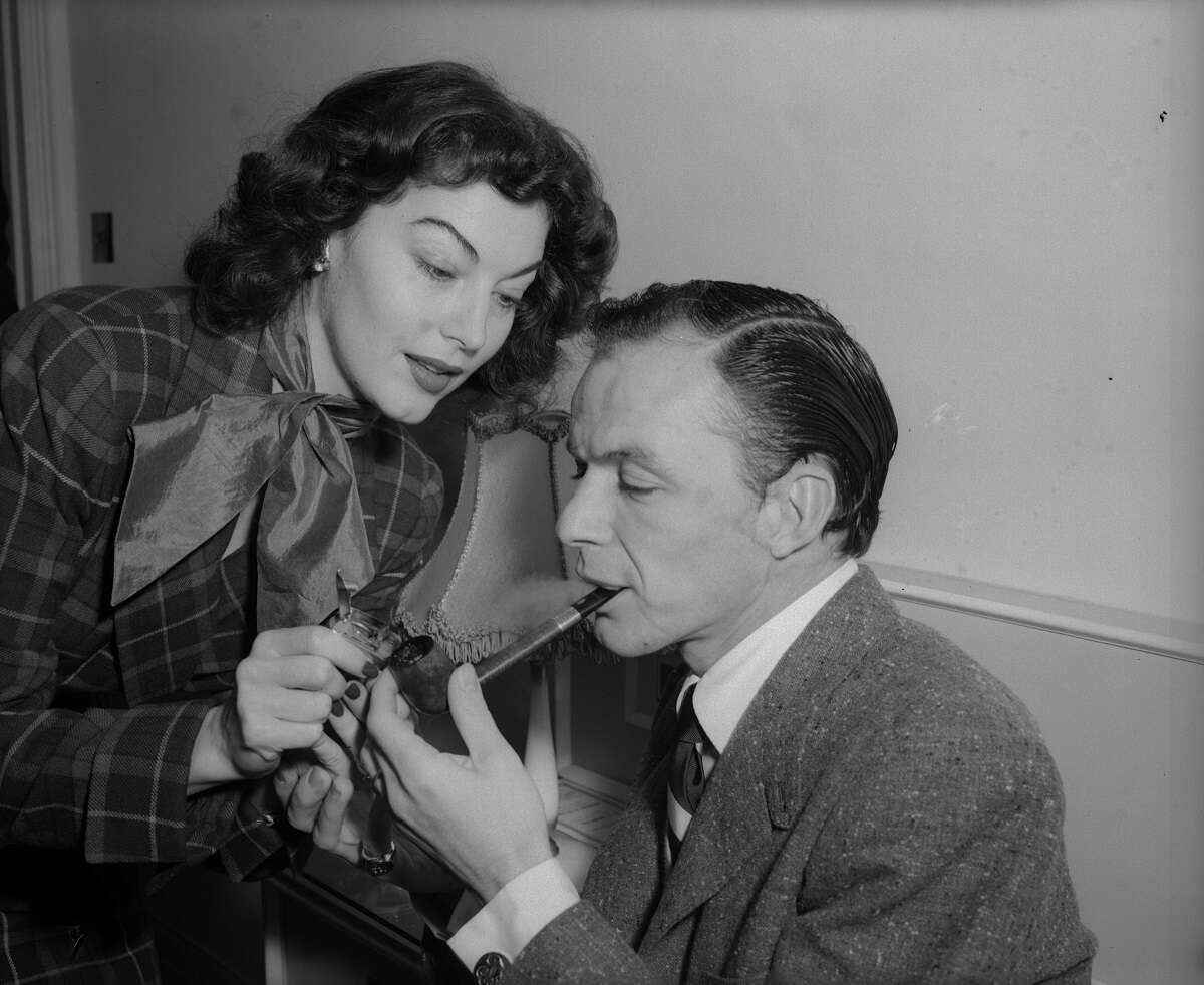 Ava Gardner lights Frank Sinatra's pipe in an undated photo