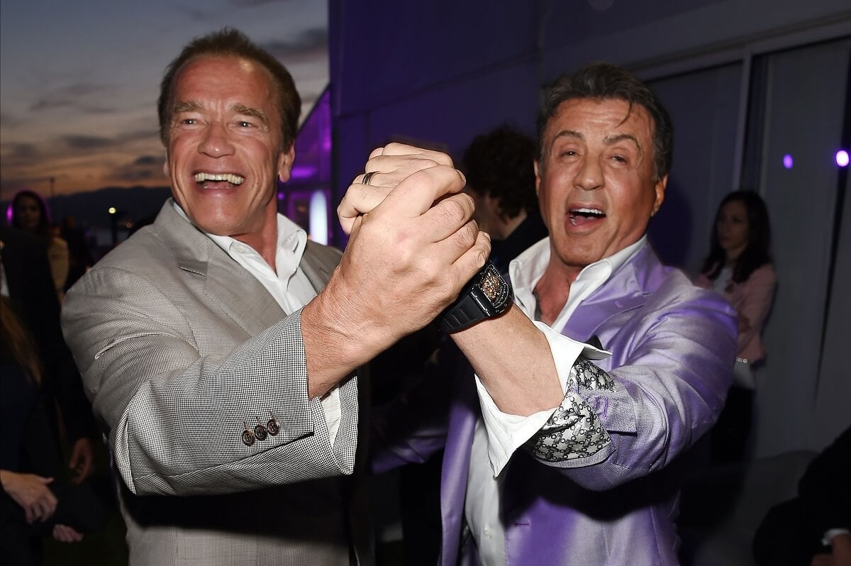 Sylvester Stallone and Arnold Schwarzenegger holding hands at the the Expendables 3 Dinner.