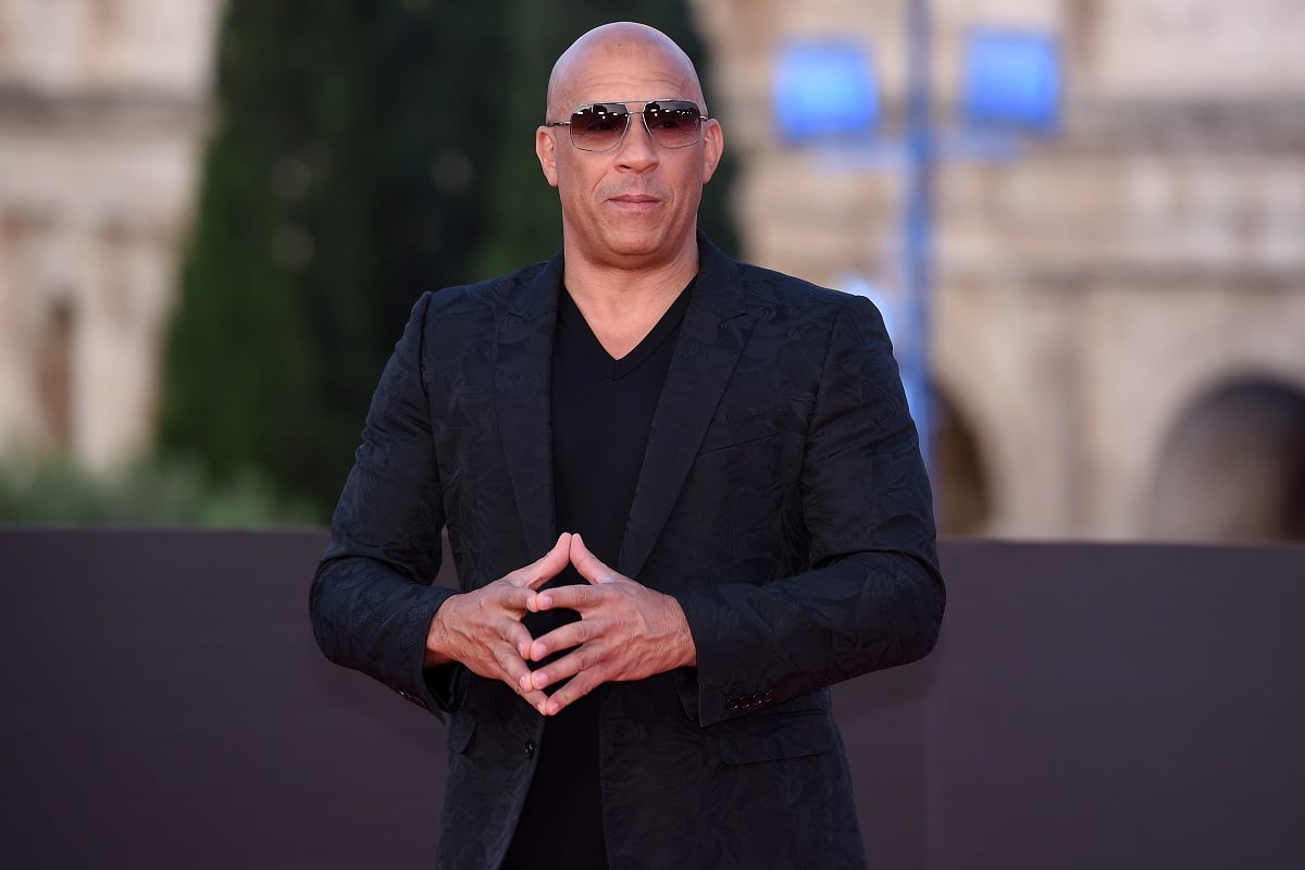 Vin Diesel posing at the 'Fast X' premiere wearing a black suit.