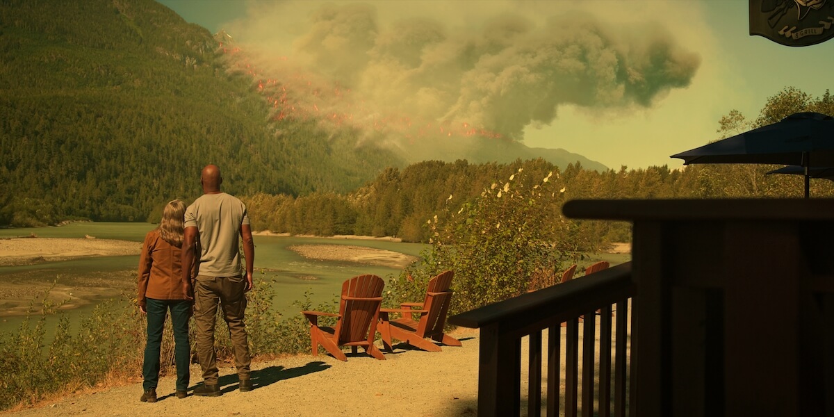 Preacher and Hope watching a wildfire on the other side of the river in 'Virgin River' Season 5 