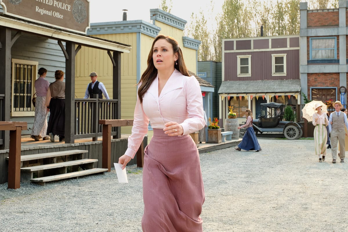 Elizabeth, dressed in pink, walking down the street in 'When Calls the Heart' Season 10