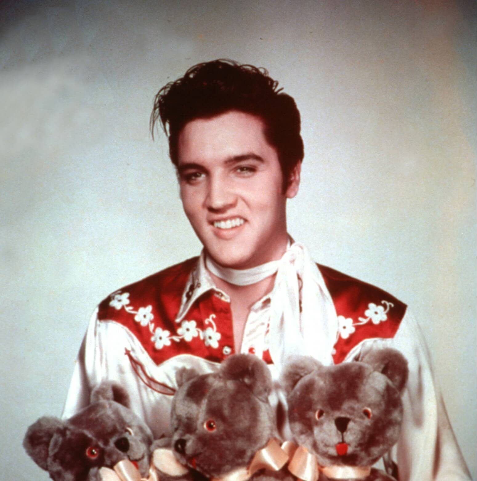 "Good Luck Charm" singer Elvis Presley holding teddy bears