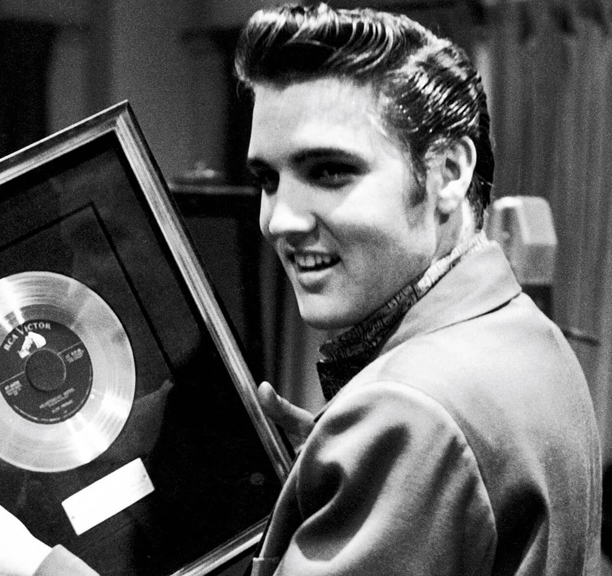 "Such a Night" singer Elvis Presley holding a record
