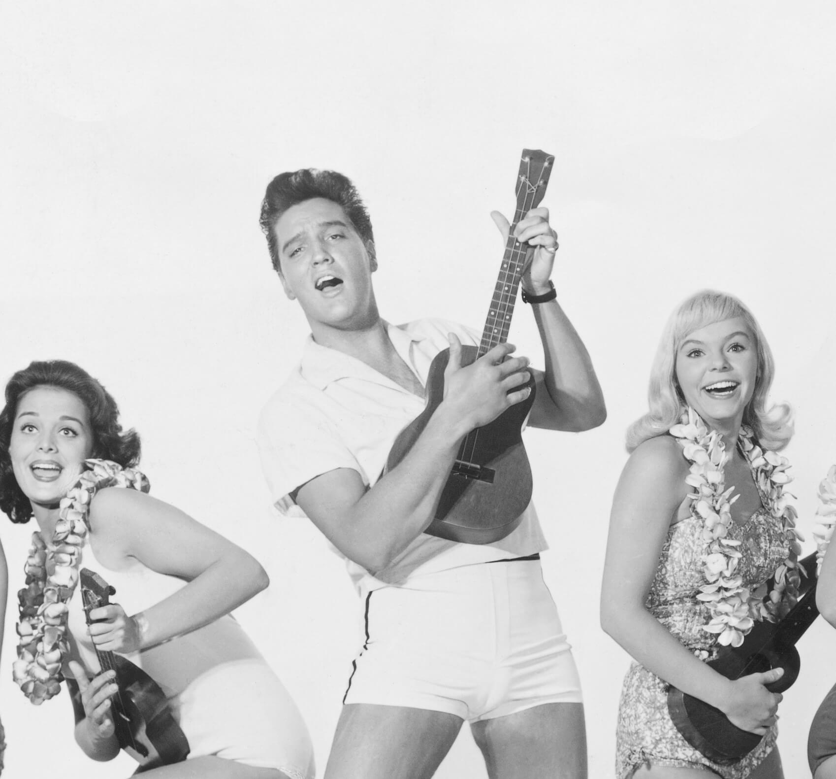 Elvis Presley and two actors in a promotional image for 'Blue Hawaii'