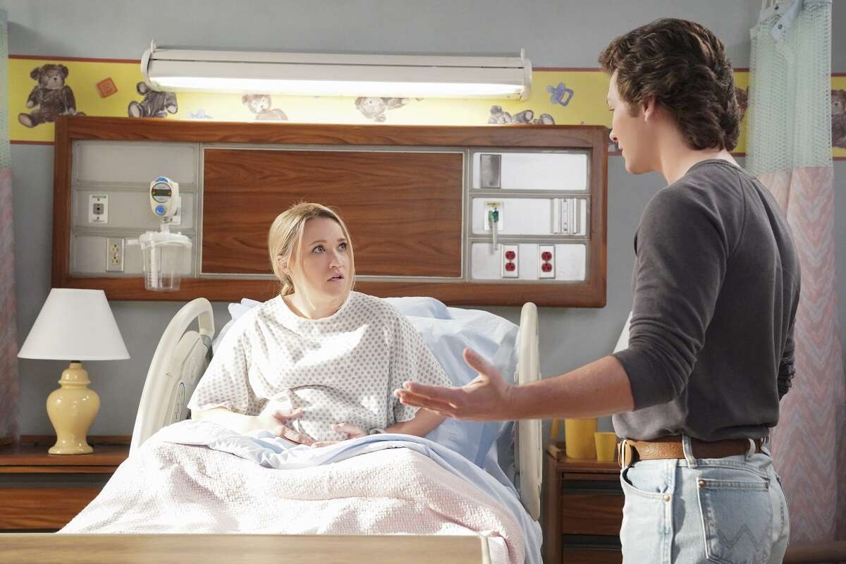 Mandy McAllister sits in a hospital bed while in labor in an episode of 'Young Sheldon'. Georgie Cooperis by her side