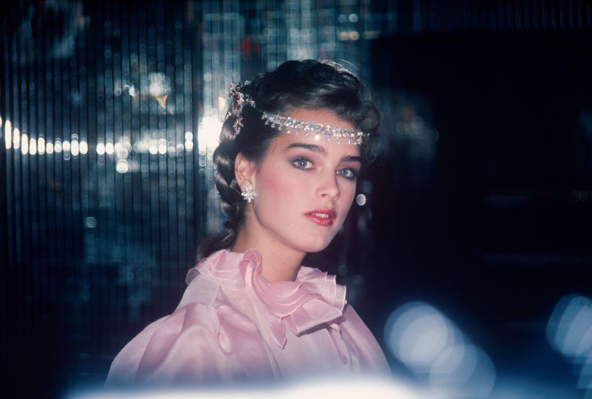 Brooke Shields wears a pink dress and a diamond headpiece.