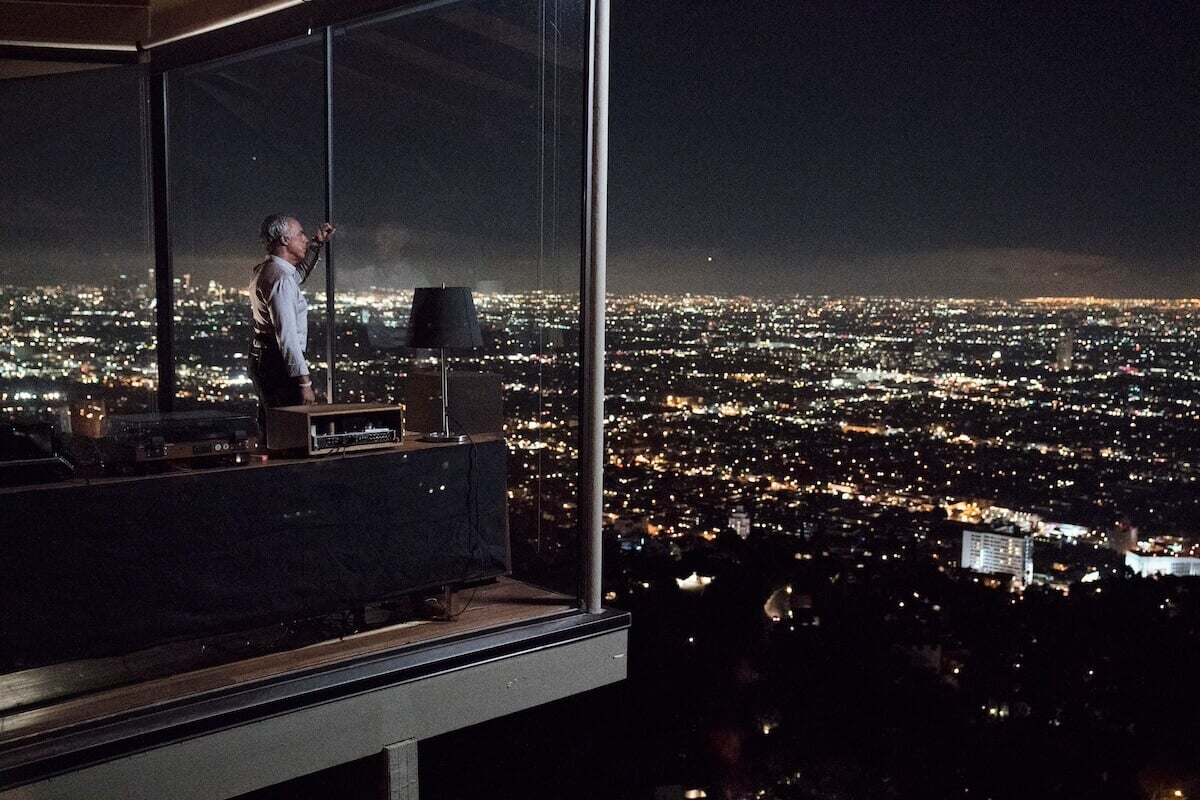 Titus Wellive as Harry Bosch in the living room of his house overlooking Los Angeles basin at night