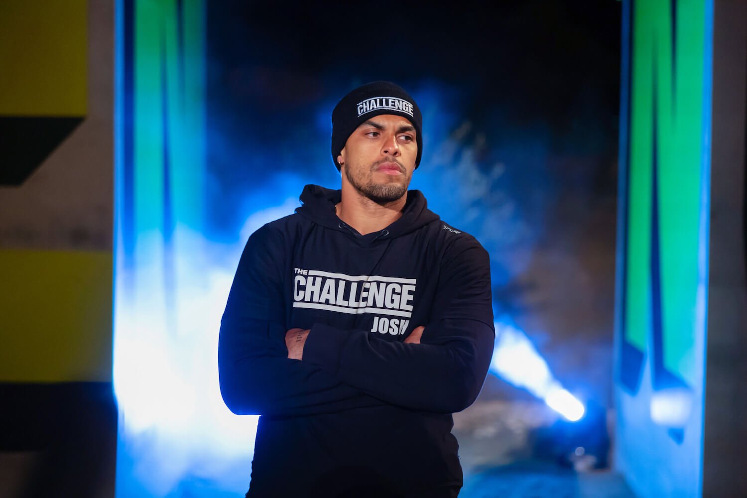 Josh Martinez with his hands across his chest looking serious in 'The Challenge: USA' Season 2
