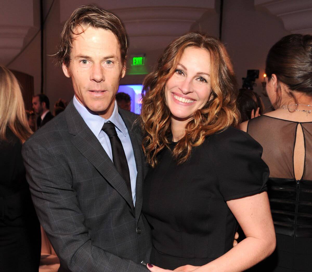 Danny Moder and Julia Roberts embrace in a crowded room.