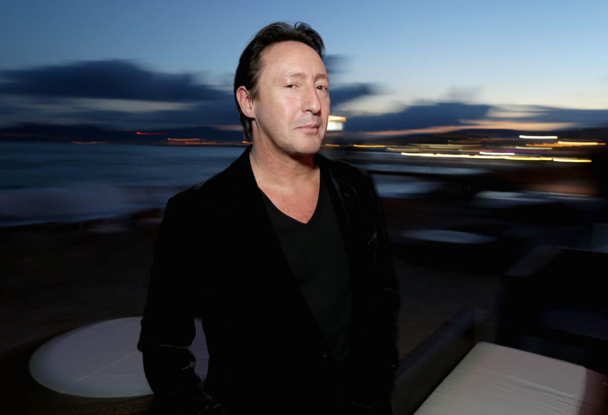 Julian Lennon wears black and stands outside.