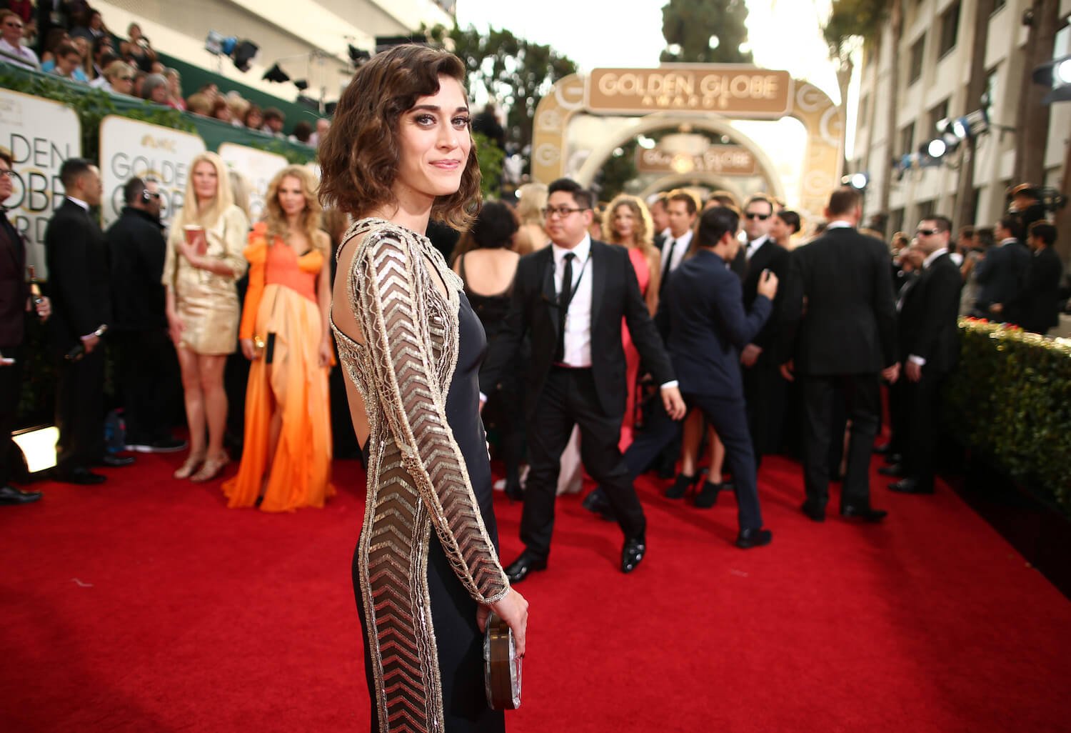 Lizzy Caplan looking over her shoulder at a red carpet event