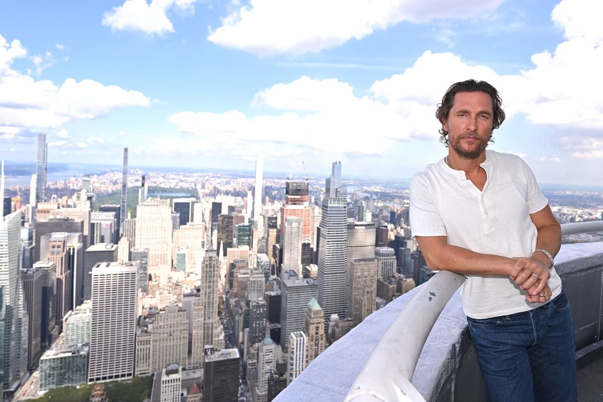 Matthew McConaughey leaning on a railing while on top of the Empire state building.