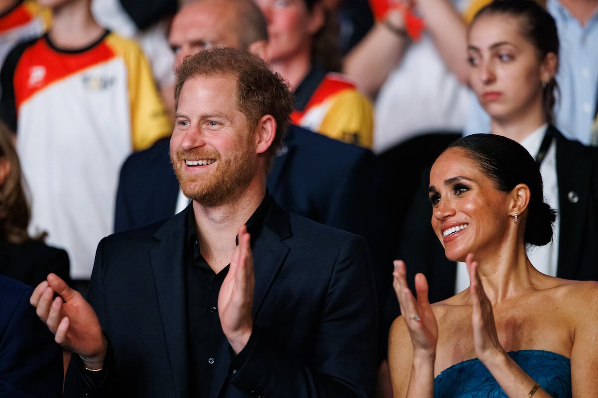 Prince Harry and Meghan Markle, who can follow in David and Victoria Beckham's footsteps with their brand, clap