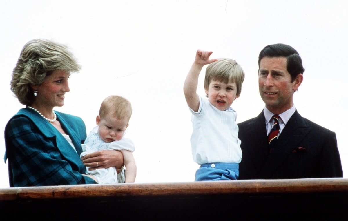 Princess Diana holds Prince Harry while then-Prince Charles holds Prince William in 1985.