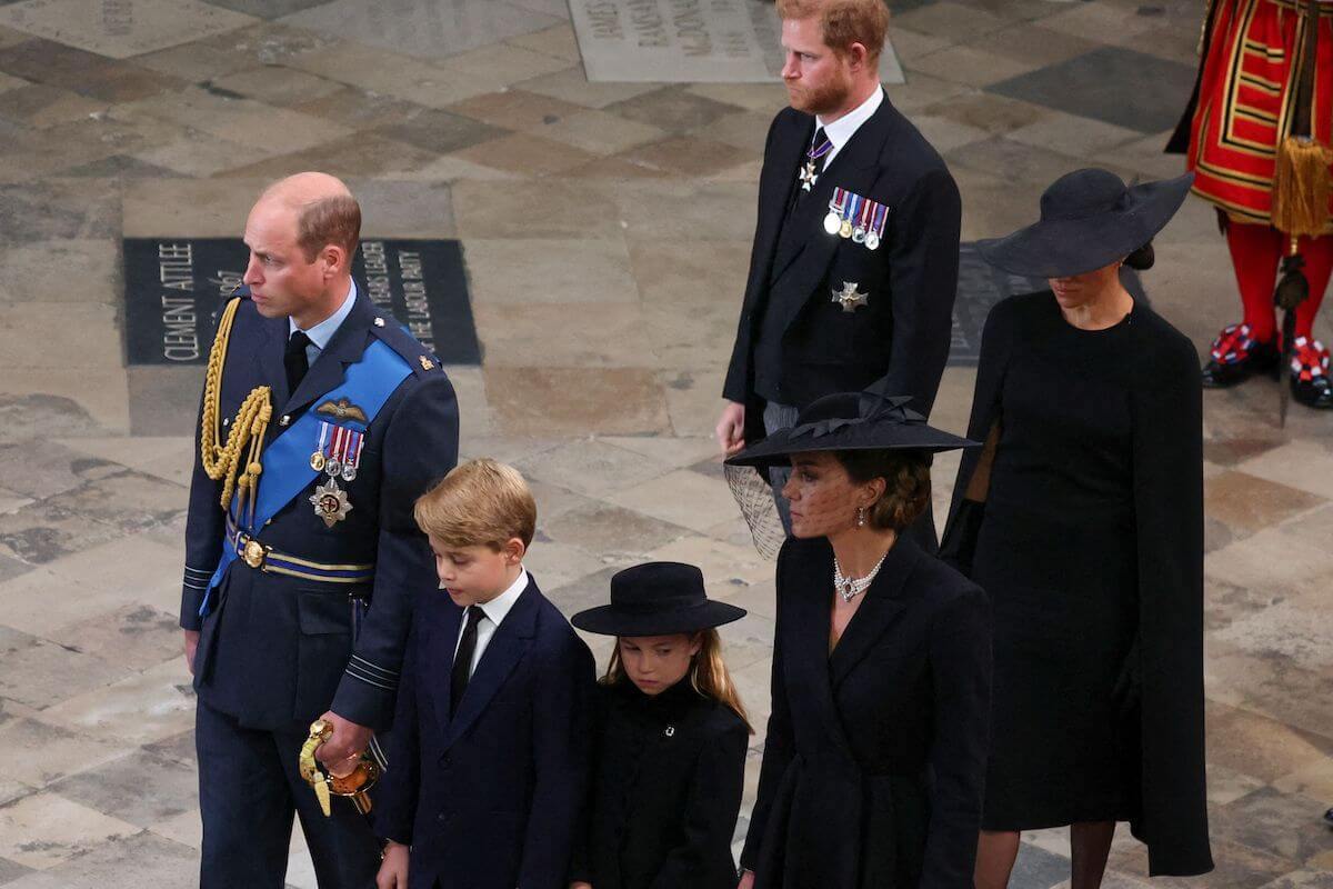 Prince William and Kate Middleton, who are reportedly 'resentful' toward Prince Harry and Meghan Markle, walk with Prince George and Princess Charlotte ahead of Prince Harry and Meghan Markle