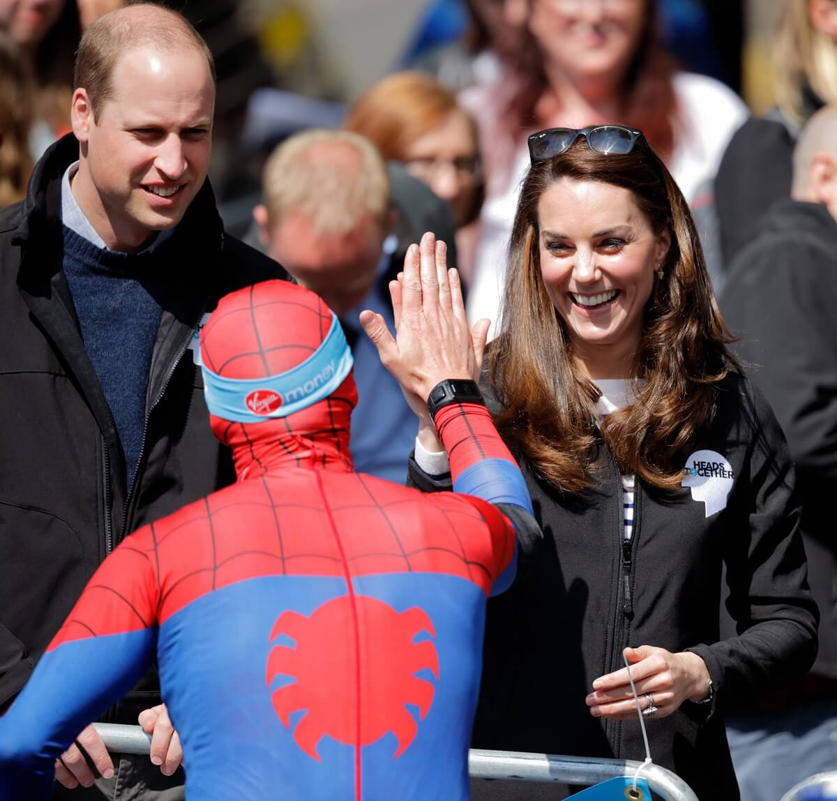 Prince William and Kate Middleton, who celebrate some Halloween traditions, meet a runner dressed as Spiderman competing in the London marathon