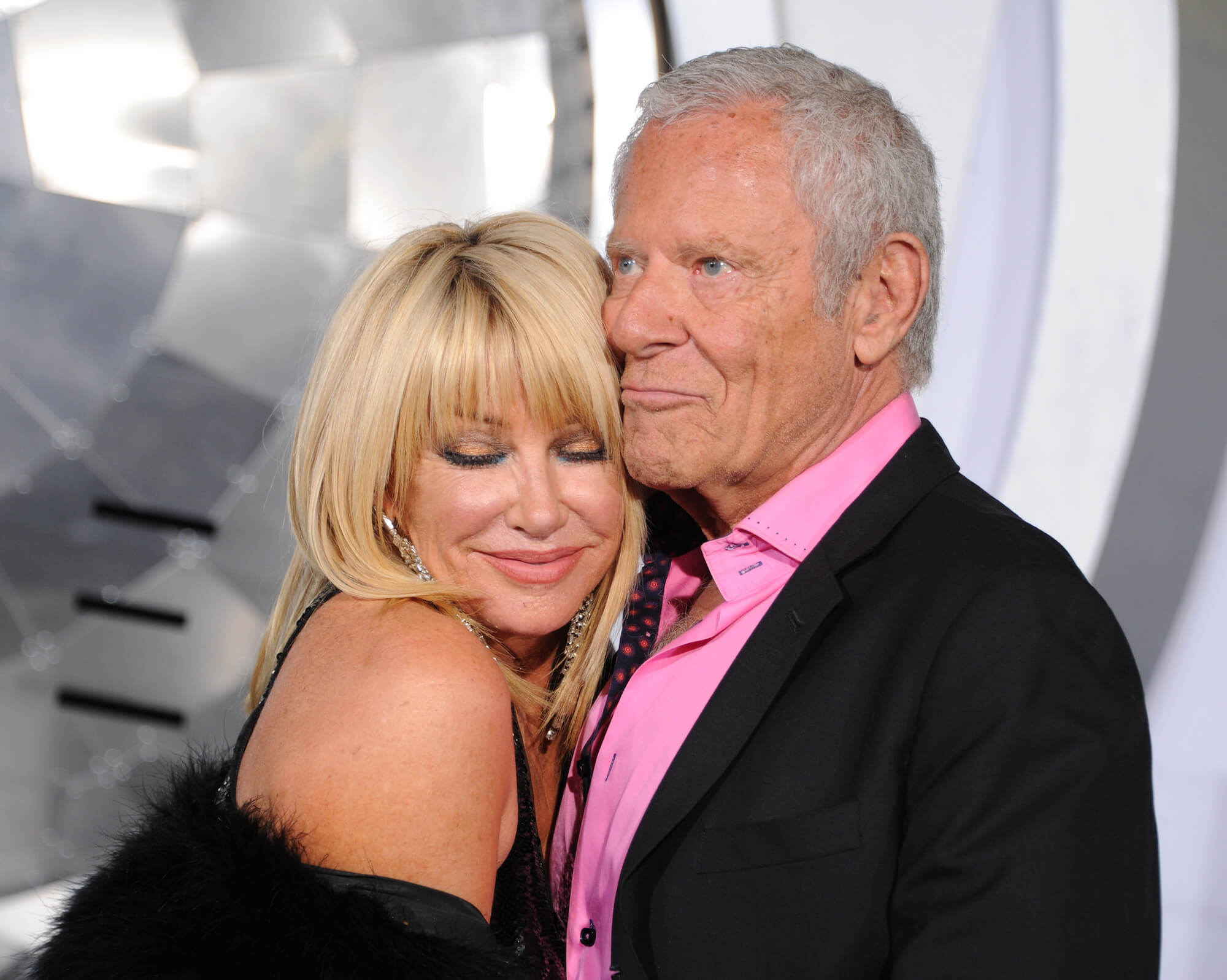 Suzanne Somers hugging her husband, Alan Hamel, with her eyes closed