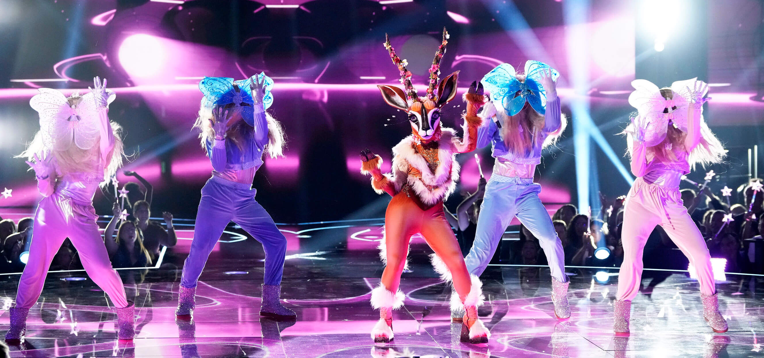 Gazelle singing on stage in 'The Masked Singer' Season 10 with four backup dancers