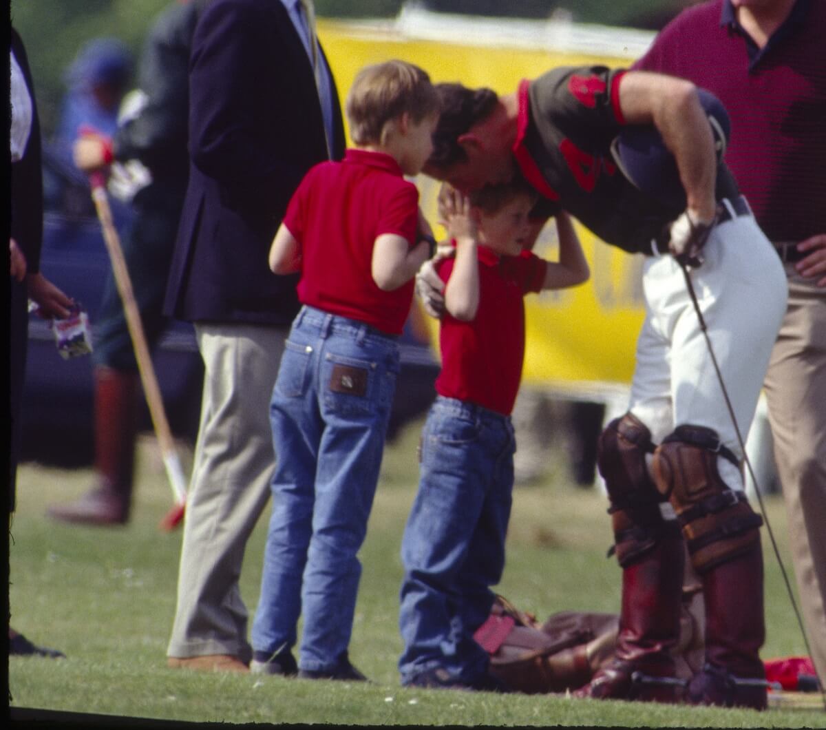 Then-Prince Charles hugging a young Prince Harry at a Polo Match